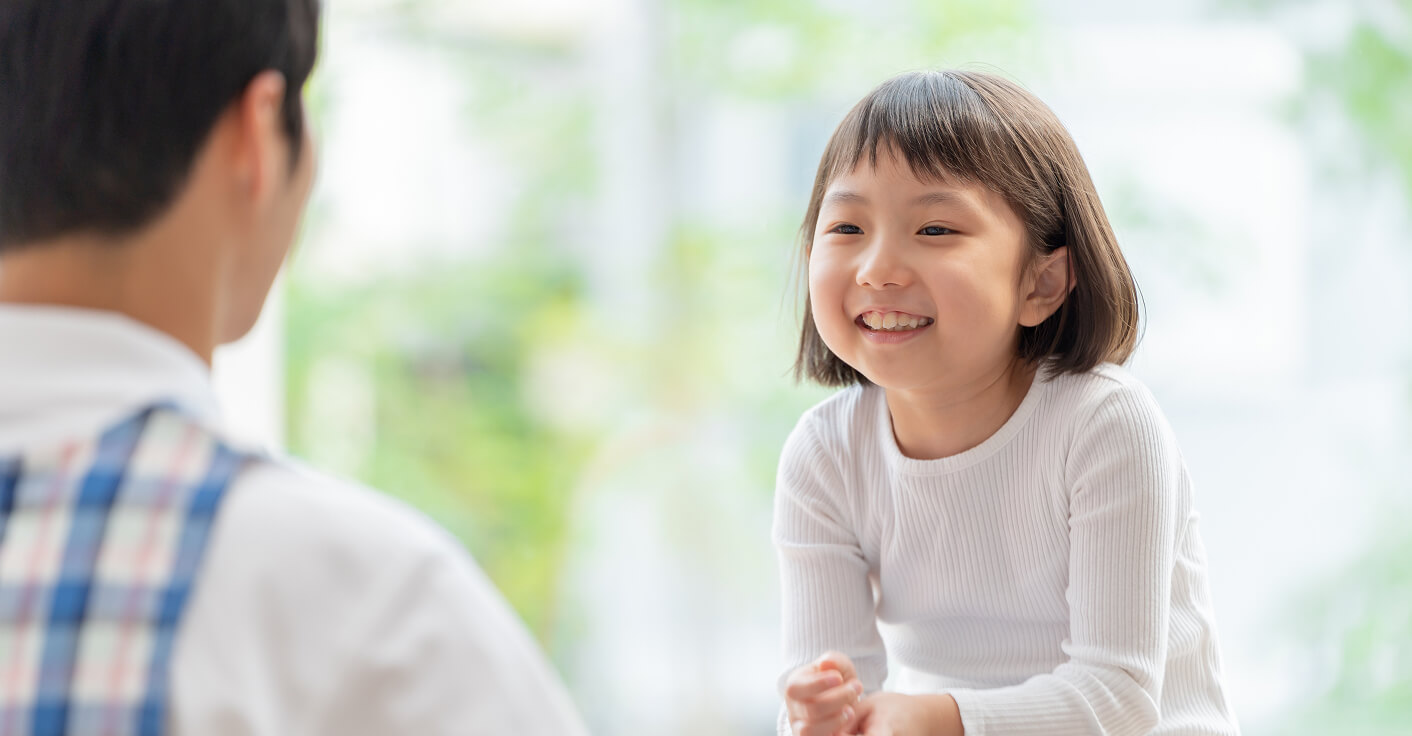 笑顔の女の子がマンツーマン指導を受けている様子